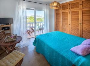 伊斯费古耶拉尔海滩Casa en Ibiza con vistas increíbles en Es Figueral的一间卧室配有一张床铺和一张桌子,并设有一个阳台