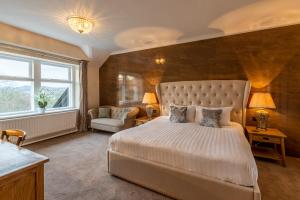 鲍内斯温德米尔Lakes Hotel & Spa的卧室配有床、椅子和窗户。