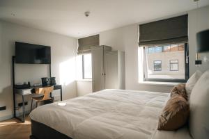 斯滕韦克MyHotel Steenwijk - Giethoorn的卧室设有一张白色大床和一扇窗户。