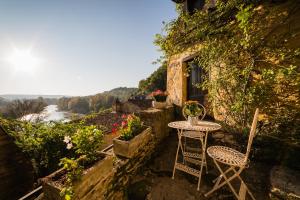 贝纳克和卡泽纳克Au coeur de Beynac, maison authentique avec vue magique sur la rivière的美景阳台配有小桌子和椅子