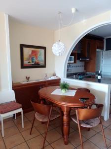 绍塞列Casa rural Las Peñas的厨房以及带木桌和椅子的用餐室。
