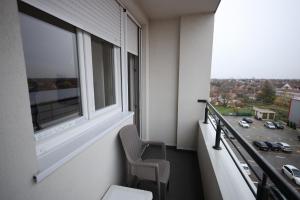 Nova PazovaApartman Lux的阳台配有椅子和窗户。