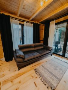 贾马里海姆森Berona Dağ Evleri的客厅设有皮沙发,配有窗户