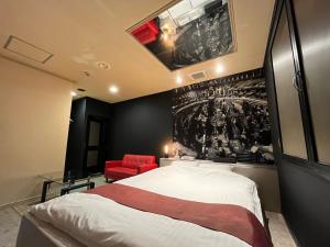 旭川旭川ホテル818-大人専用的一间卧室配有一张大床和一张红色椅子