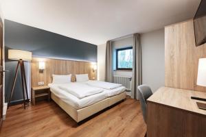 慕尼黑Hotel Schleuse的配有一张床和一张书桌的酒店客房