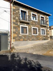 绍塞列Casa rural Las Peñas的砖砌建筑,设有窗户和阳台
