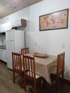 弗洛里亚诺波利斯Pousada Porto do Torquato的厨房配有桌椅和冰箱。