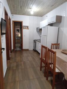 弗洛里亚诺波利斯Pousada Porto do Torquato的一间带桌子和冰箱的小厨房