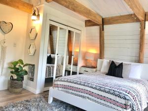 大熊湖Maison Solange-Red Barn Farmhouse Style- Moonridge的卧室配有白色的床和镜子