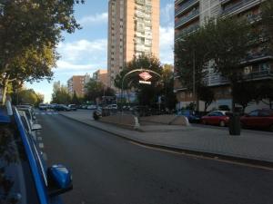 马德里HELLO HOME FERIA的一条城市街道,路边有汽车停放