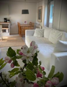 BurgsvikGåsen Out的客厅配有白色的沙发和带鲜花的桌子