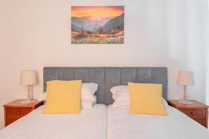 卡马查Cantinho Rural的一间卧室配有一张带两盏灯和一幅画的床铺