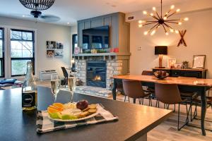 蒙特朗布朗Rental condo Tremblant-les-Eaux的厨房以及带餐桌和一盘食物的客厅。