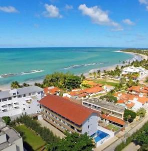 塔曼达雷Praia dos carneiros flat hotel的城市和海洋的空中景观