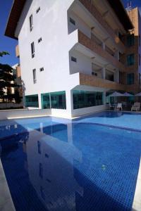 塔曼达雷Praia dos carneiros flat hotel的大楼前的大型游泳池