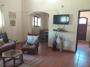 蒂尔卡拉Casona Inkill Huasi II的客厅配有椅子和平面电视