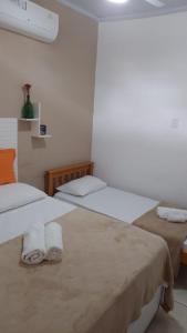 阿布拉奥Suíte da Vila - Beira Mar的两张位于酒店客房的床,配有毛巾