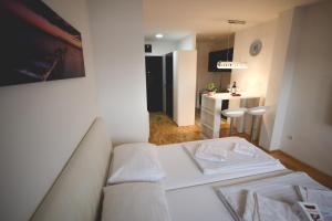 Nova PazovaApartman Lux的一间带白色沙发的客厅和一间厨房