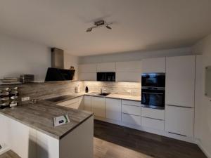 马克莱贝格Leipziger Neuseenland Apartment的厨房配有白色橱柜和台面
