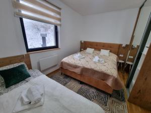 亚霍里纳Cozy Ski Apartment Jahorina的小型客房 - 带2张床和窗户