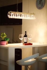 Nova PazovaApartman Lux的柜台上的一瓶葡萄酒和两杯酒杯