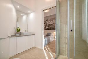 阿尔盖罗RelaisApartments MERCEDE - Extraordinary Hospitality的一间带玻璃淋浴和水槽的浴室