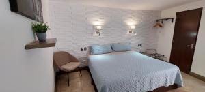 图斯特拉古铁雷斯Palmareca Inn-Suites-Studio的一间小卧室,配有一张床和一把椅子