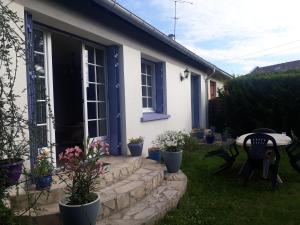 塞夫朗Paris Magic - Villepinte Exhibition Center的白色的房子,设有蓝色的窗户和庭院