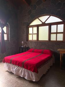 San Lucas TolimánCasa Qatzij - Guest House, Lake Atitlan的一间卧室设有一张红色大床和窗户
