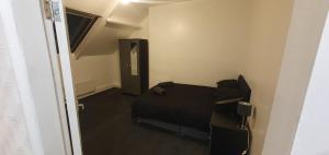 泰恩河畔纽卡斯尔Hustlers inn apartment的一间卧室设有一张黑色的床和一个走廊