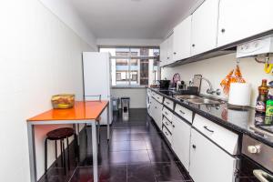 PaiõisAL Cacém的厨房配有白色橱柜和橙色台面