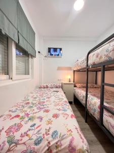 马拉加Nuestro Rinconcito del Soho的一间带两张双层床和电视的卧室