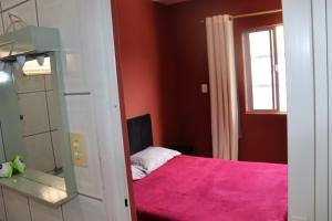 纳韦甘蒂斯Casa de praia da Kenna, centro的卧室配有粉红色的床和镜子