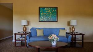圣罗莎Vintners Resort的客厅配有蓝色的沙发和2张桌子