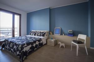 米兰米兰比可卡公寓酒店的一间卧室设有一张床和蓝色的墙壁