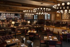 圣安东尼奥欧姆尼里奥大厦酒店的餐厅设有桌椅和吊灯。