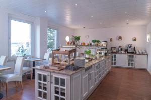 多特蒙德NP Hotel Königshof的厨房配有白色橱柜和桌椅