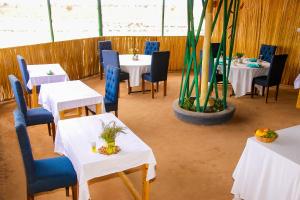 安博塞利Amanya Camp 1-Bed Tent Elephant Suite in Amboseli的用餐室配有白色的桌子和蓝色的椅子