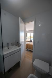 埃斯特角城SYRAH Premium B2 - Piscina privada con vista al mar by depptö的一间带水槽和卫生间的浴室以及一间卧室