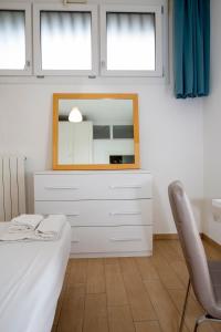 米兰Rucellai Guest House的一间卧室配有带镜子和椅子的梳妆台
