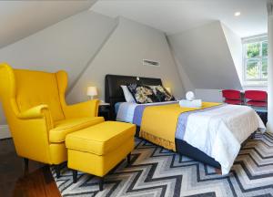 悉尼Kent Terrace的一间卧室配有两张床和一张黄色椅子