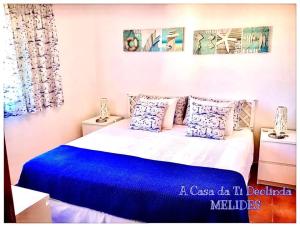 梅利迪什A Casa da Ti Deolinda的一间卧室配有一张大床,提供蓝色的床单和枕头
