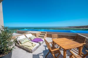 埃斯特角城SYRAH Premium B2 - Piscina privada con vista al mar by depptö的庭院配有木桌、椅子、桌子和桌子。