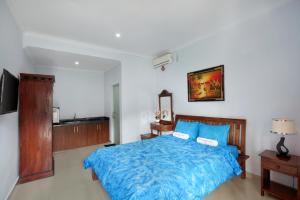 库塔Graha Wedha Suite Kuta by kamara的一间卧室配有一张带蓝色棉被的床