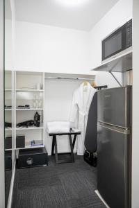 奥克兰Solsen Flexi-Stay的厨房配有白色的外套,放在桌子和椅子上