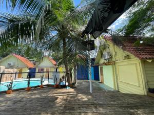 马尼拉MAH Resort by Cocotel的棕榈树,旁边是一座带游泳池的房子