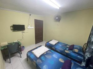 Kampong Alor GajahIkhlas Roomstay的客房设有床、书桌和电视。