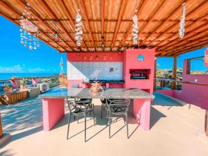 伊塔卡雷Vila Real Apartamentos的粉红色的厨房,甲板上配有桌椅