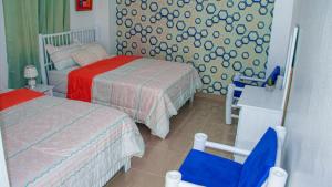 佩德纳莱斯D´ Yoko Village´s的一间小卧室,配有两张床和一张蓝色椅子