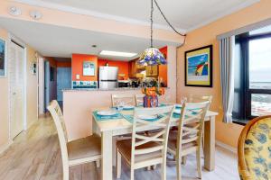 大洋城Sea Watch 1110的用餐室以及带橙色墙壁和桌椅的厨房